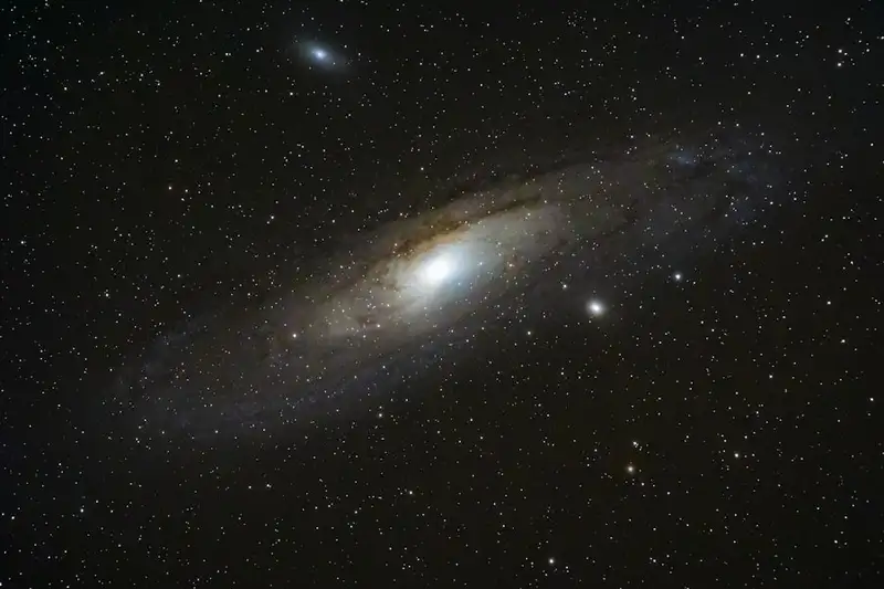 Céu noturno límpido repleto de estrelas e constelações visíveis sobre dunas de areia