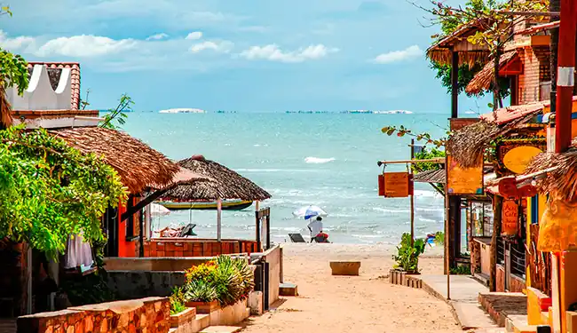 Vista panorâmica da praia de Jericoacoara com mar calmo e dunas ao fundo no Ceará