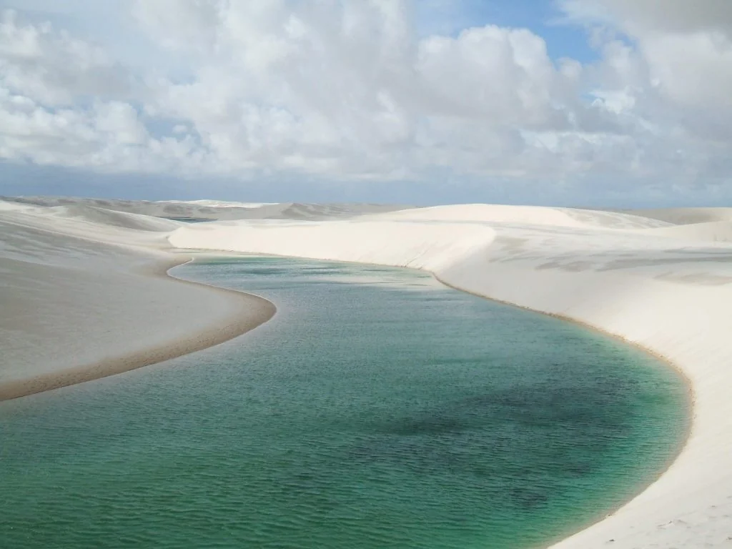 Vista ampla das dunas e lagoas dos Lençóis Maranhenses sob céu azul