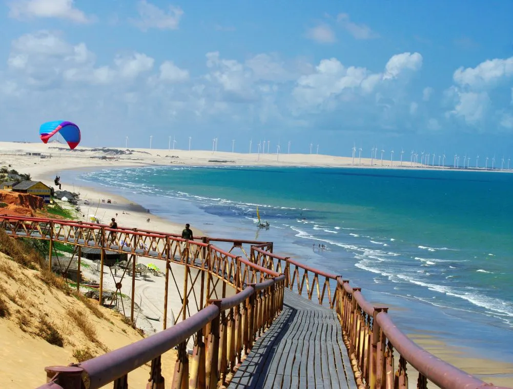 Falésias avermelhadas e mar azul contrastando na costa do Ceará
