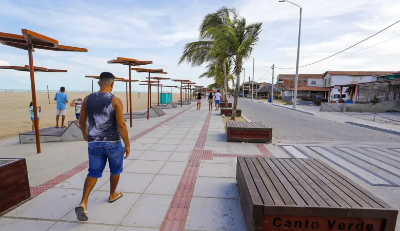Calçadão da orla de Bitupitá com bancos de madeira, coberturas metálicas e coqueiros, ao lado da faixa de areia da praia