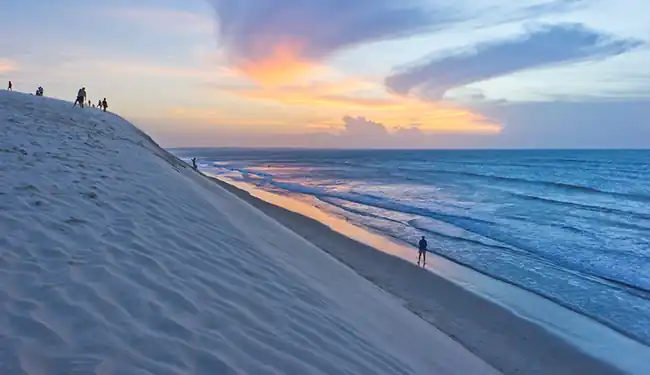 Ruela rústica de areia com iluminação aconchegante e pousadas de charme em Barra Grande no Piauí